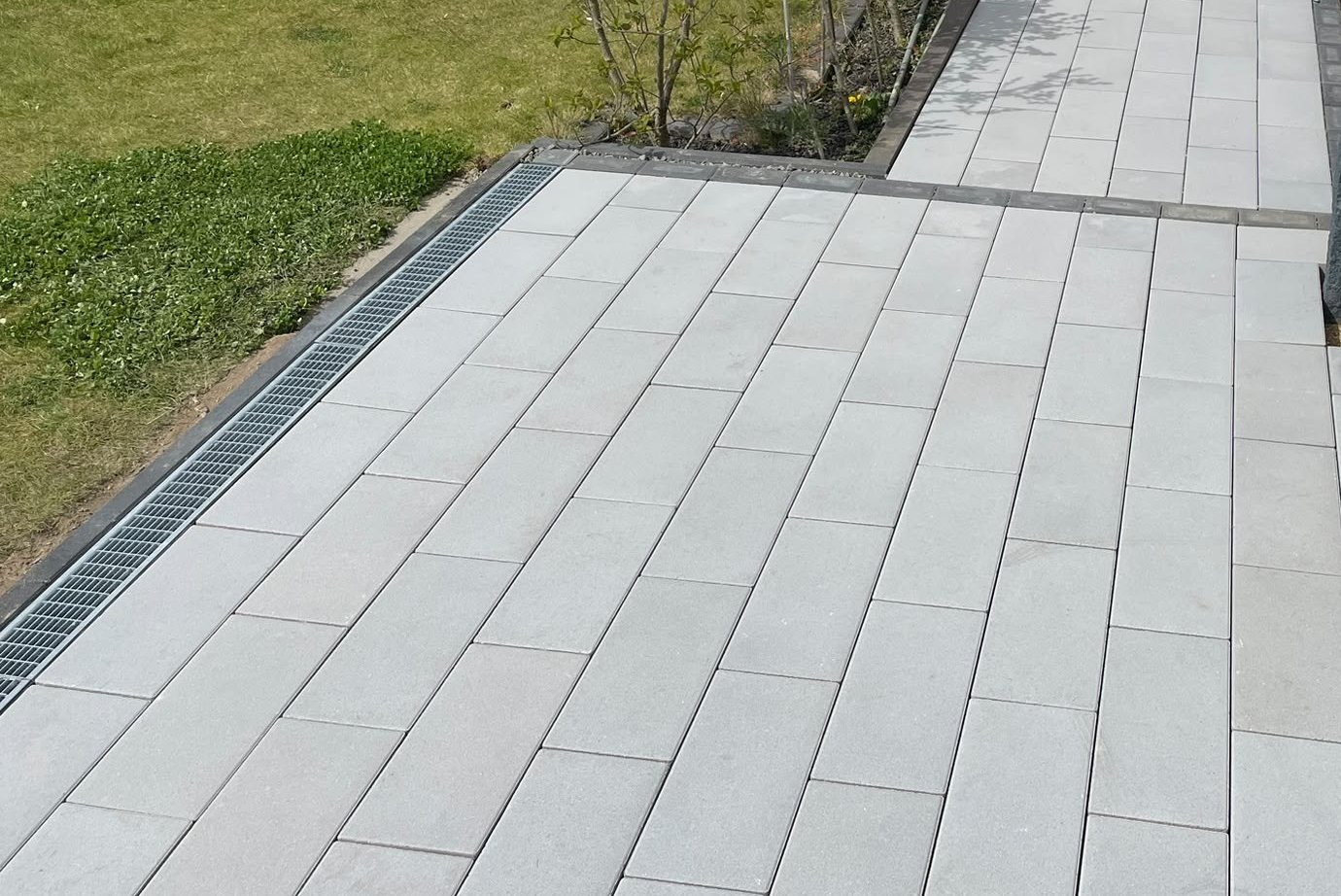 Neuer Plattenweg im Garten mit Entwässerungsrinne